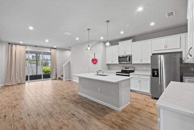 kitchen with light wood-style flooring, a sink, visible vents, light countertops, and appliances with stainless steel finishes