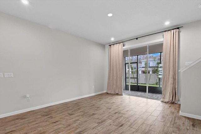 unfurnished room with baseboards, wood finished floors, and recessed lighting