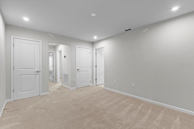 empty room with light carpet, baseboards, visible vents, and recessed lighting