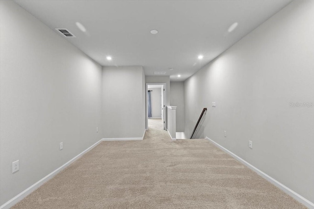 spare room with carpet floors, recessed lighting, visible vents, and baseboards