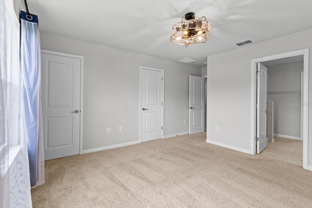 unfurnished bedroom featuring carpet floors, visible vents, and baseboards