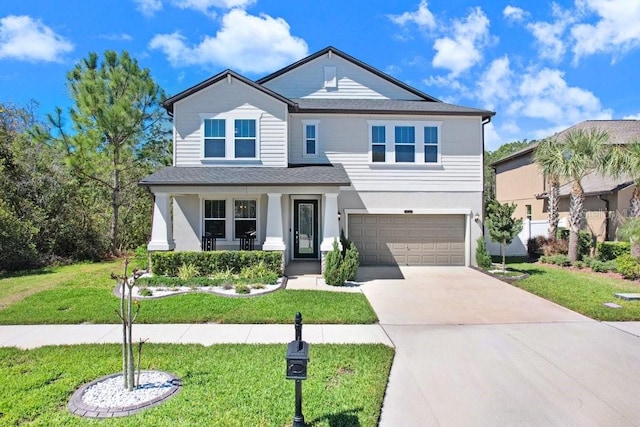 traditional-style house featuring driveway, a garage, a front yard, a porch, and stucco siding