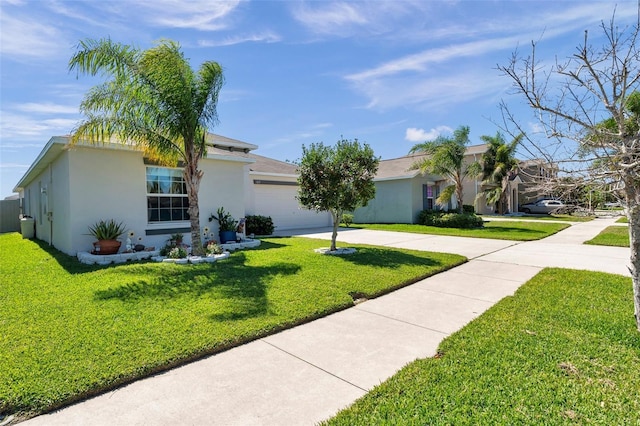 ranch-style house with a garage, concrete driveway, a front lawn, and stucco siding