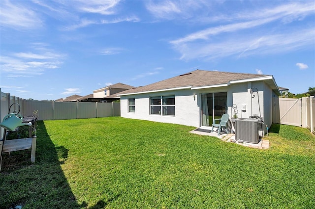 back of property featuring central AC, a yard, a fenced backyard, and stucco siding