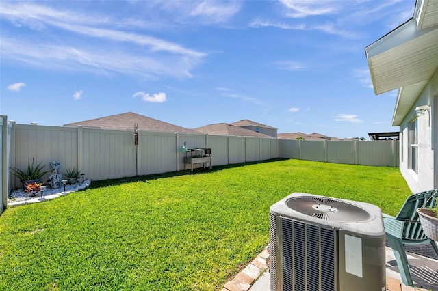 view of yard featuring a fenced backyard and central AC