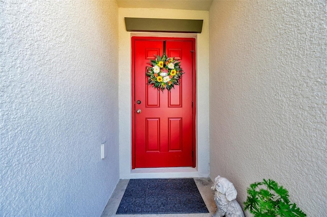 property entrance with stucco siding