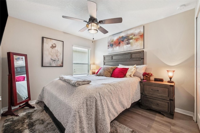 bedroom featuring light wood-type flooring, ceiling fan, and baseboards