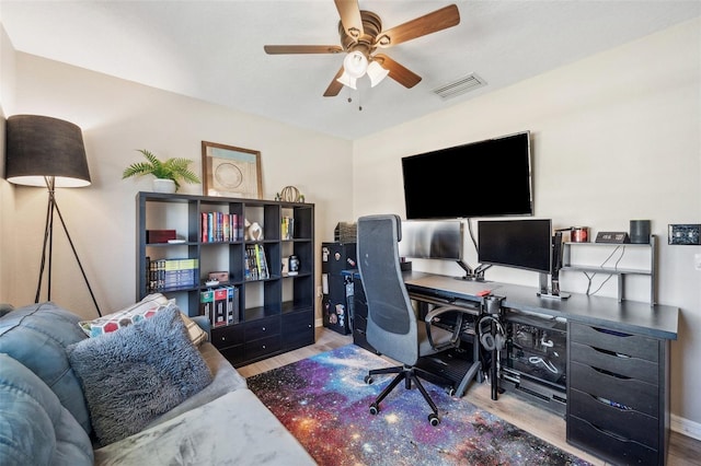 home office with visible vents, ceiling fan, baseboards, and wood finished floors