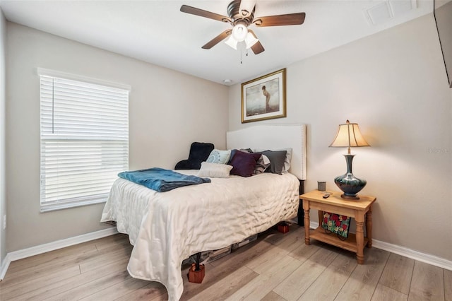 bedroom with light wood-type flooring, visible vents, and baseboards