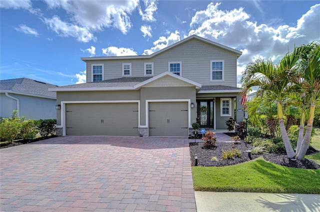 view of front of property with a garage, decorative driveway, and stucco siding