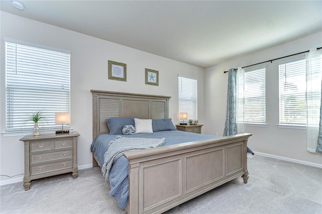 bedroom featuring light carpet and baseboards