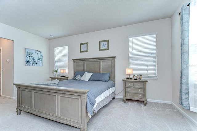 bedroom featuring baseboards and light colored carpet