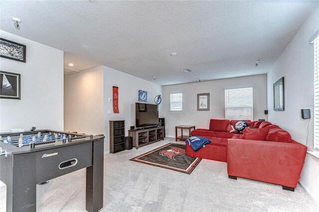 carpeted living room with a textured ceiling, visible vents, and baseboards