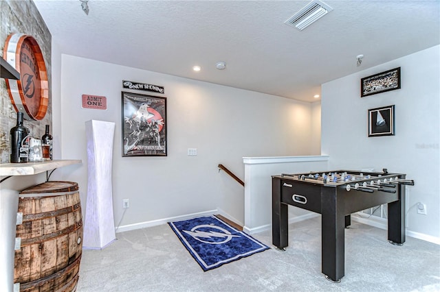 rec room featuring baseboards, visible vents, a textured ceiling, and carpet flooring