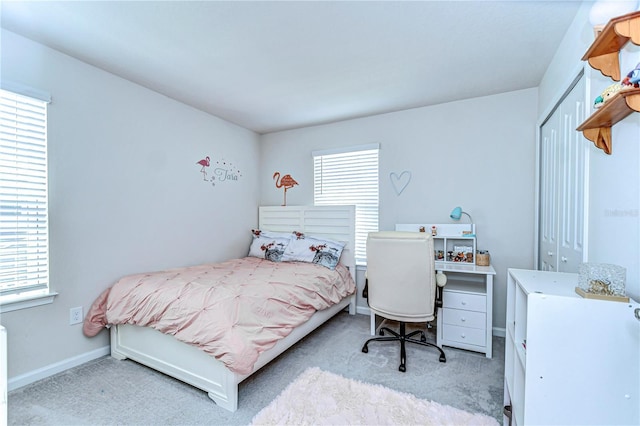 carpeted bedroom featuring a closet and baseboards