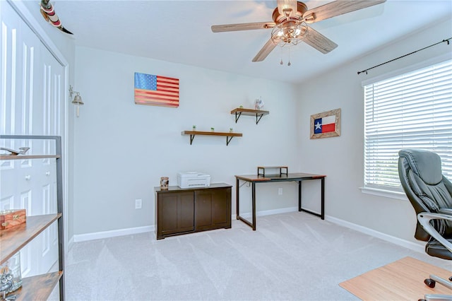 home office featuring light carpet, ceiling fan, and baseboards