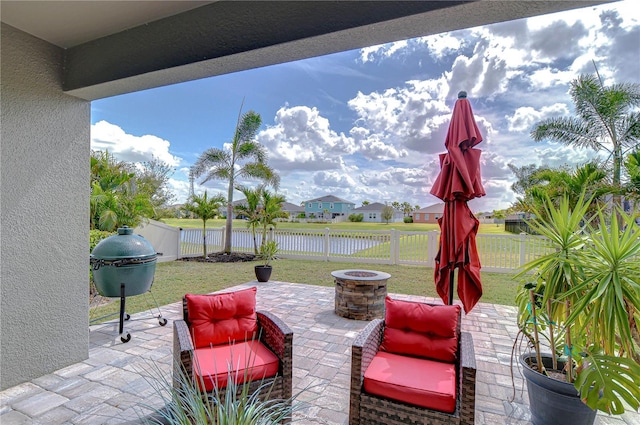 view of patio / terrace featuring an outdoor fire pit, a water view, and a fenced backyard