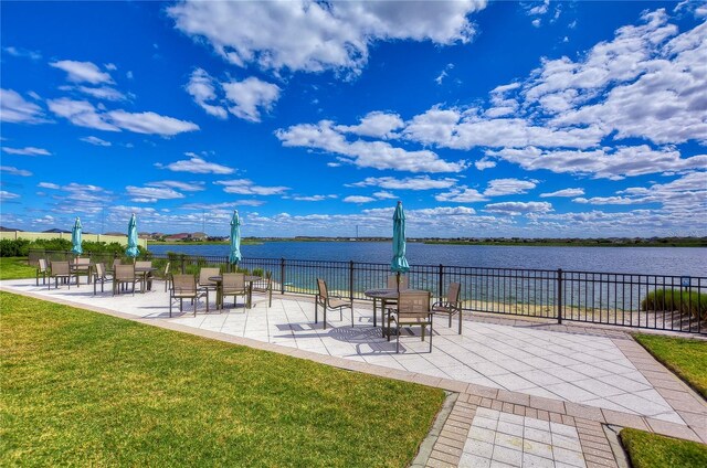 view of home's community featuring a water view, a yard, a patio, and fence