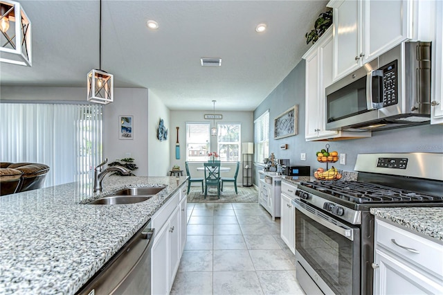 11605 Cleyera Ct, Riverview, FL 33579 - kitchen featuring stainless steel appliances, a sink, white cabinets, light stone countertops, and recessed lighting