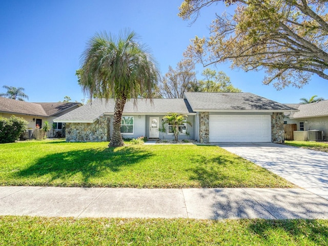 single story home with driveway, stone siding, an attached garage, a front lawn, and central AC