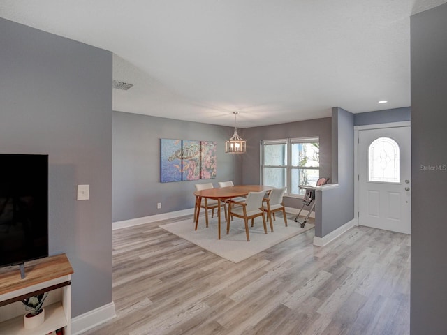 dining room featuring light wood-style floors, baseboards, and visible vents