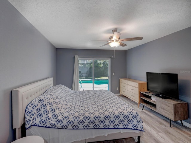 bedroom with light wood-type flooring, access to exterior, ceiling fan, and a textured ceiling