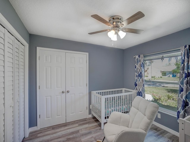 bedroom featuring multiple windows, baseboards, and wood finished floors