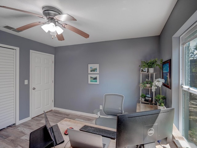 office area featuring a ceiling fan, baseboards, visible vents, and wood finished floors