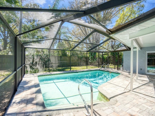 view of pool with a fenced in pool, glass enclosure, a fenced backyard, and a patio