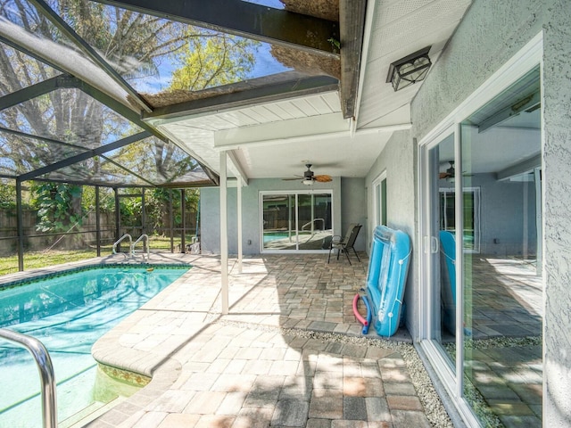 view of pool with a ceiling fan, glass enclosure, a fenced backyard, and a patio