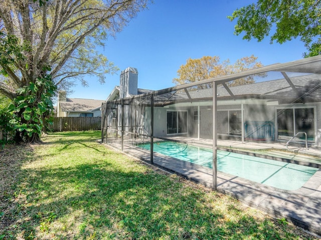 back of property with a fenced in pool, a yard, a patio area, glass enclosure, and fence