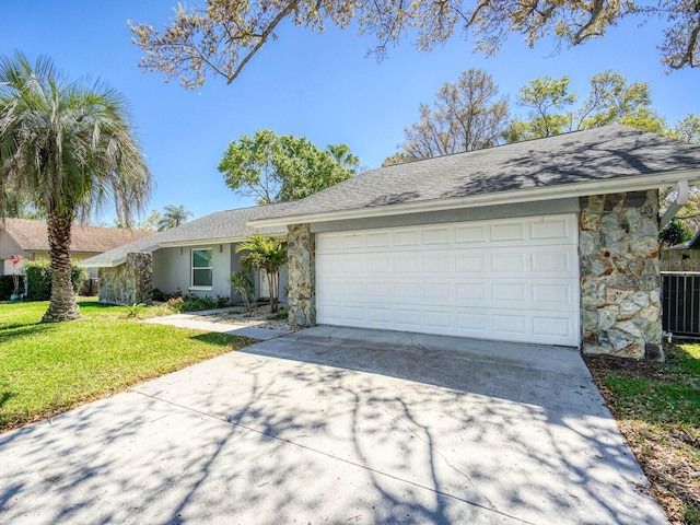 ranch-style home with a garage, stone siding, driveway, and a front yard