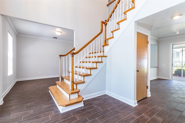 staircase with baseboards, ornamental molding, a textured ceiling, and wood tiled floor