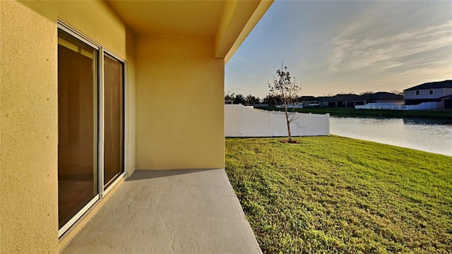 view of yard featuring fence and a water view