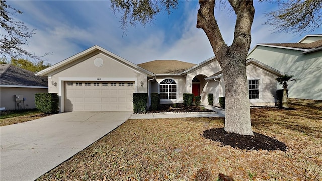 ranch-style home featuring a garage, concrete driveway, and stucco siding