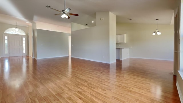 unfurnished living room with high vaulted ceiling, light wood-type flooring, ceiling fan, and baseboards