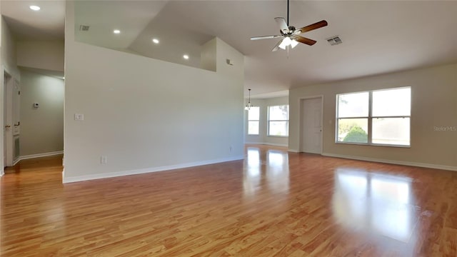 empty room with light wood-style floors, visible vents, baseboards, and ceiling fan with notable chandelier