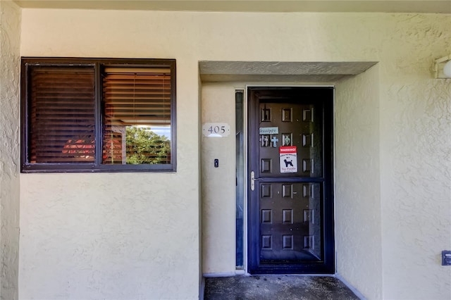 doorway to property featuring stucco siding