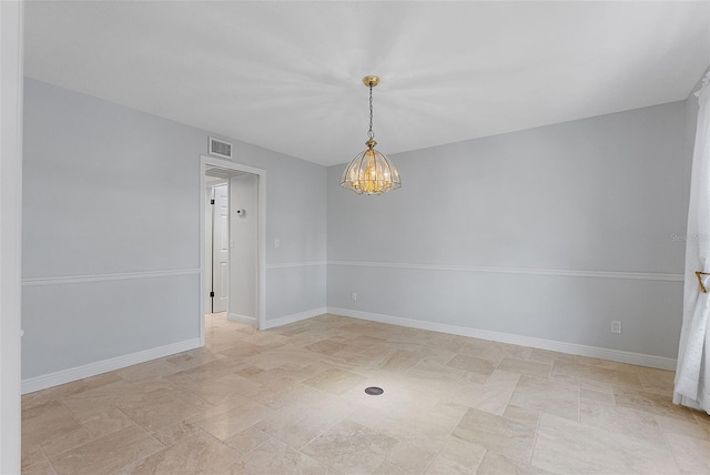 unfurnished room with a notable chandelier, visible vents, and baseboards