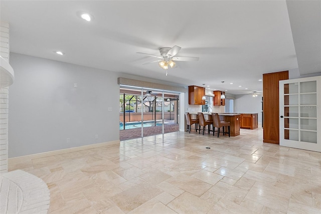 empty room with recessed lighting, a ceiling fan, and baseboards