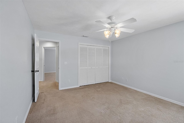 unfurnished bedroom featuring a ceiling fan, visible vents, baseboards, carpet floors, and a closet