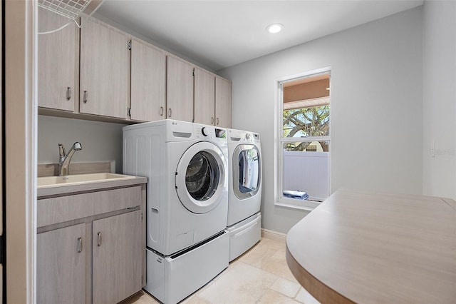 laundry area featuring washer and clothes dryer, a sink, recessed lighting, cabinet space, and baseboards