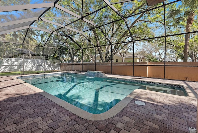 view of swimming pool featuring a patio area, glass enclosure, fence, and a fenced in pool