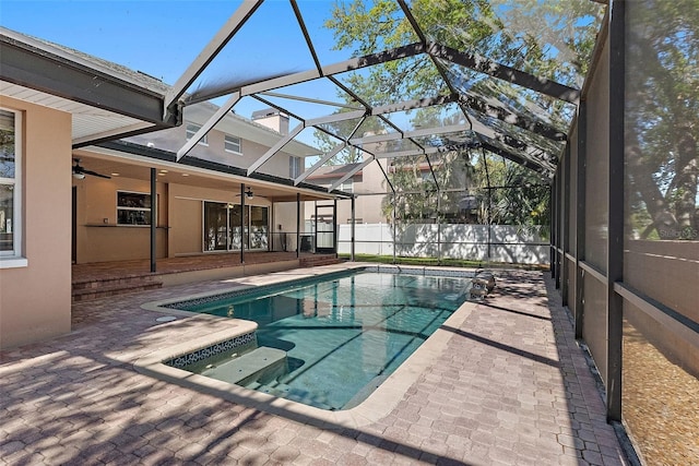 view of swimming pool featuring a patio, fence, a lanai, and ceiling fan