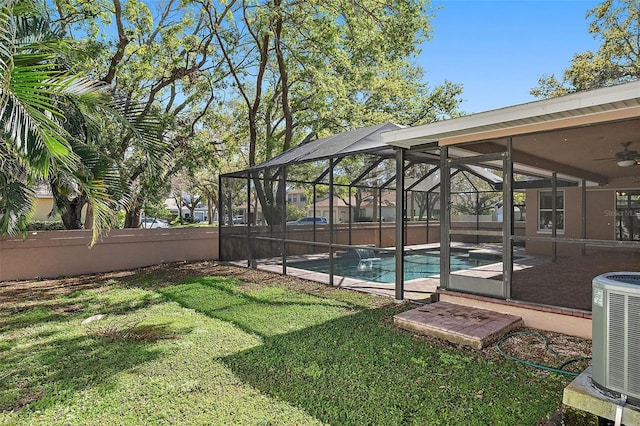 view of yard featuring glass enclosure, cooling unit, a fenced backyard, and a fenced in pool