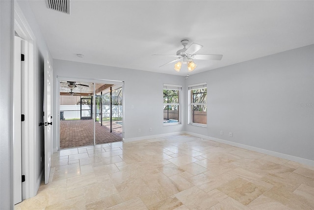 unfurnished room with visible vents, a ceiling fan, stone finish flooring, a sunroom, and baseboards