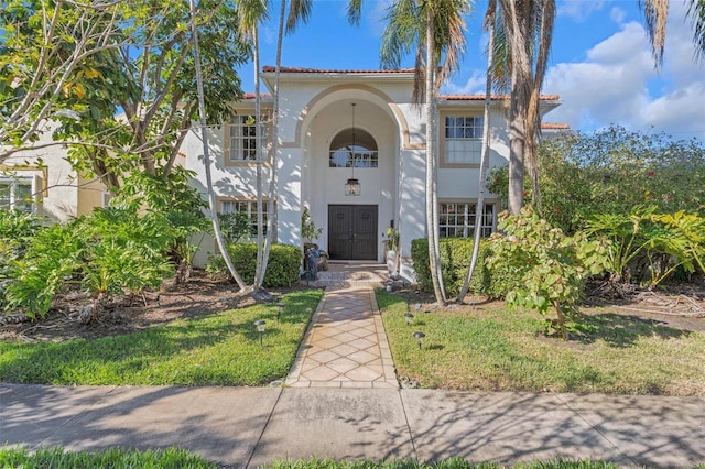 mediterranean / spanish-style house featuring a tile roof and stucco siding