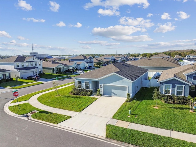 view of front of property with driveway, an attached garage, a residential view, and a front yard