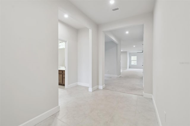 corridor with recessed lighting, visible vents, and baseboards