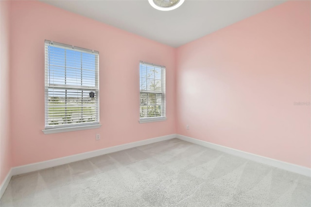 empty room featuring carpet flooring and baseboards